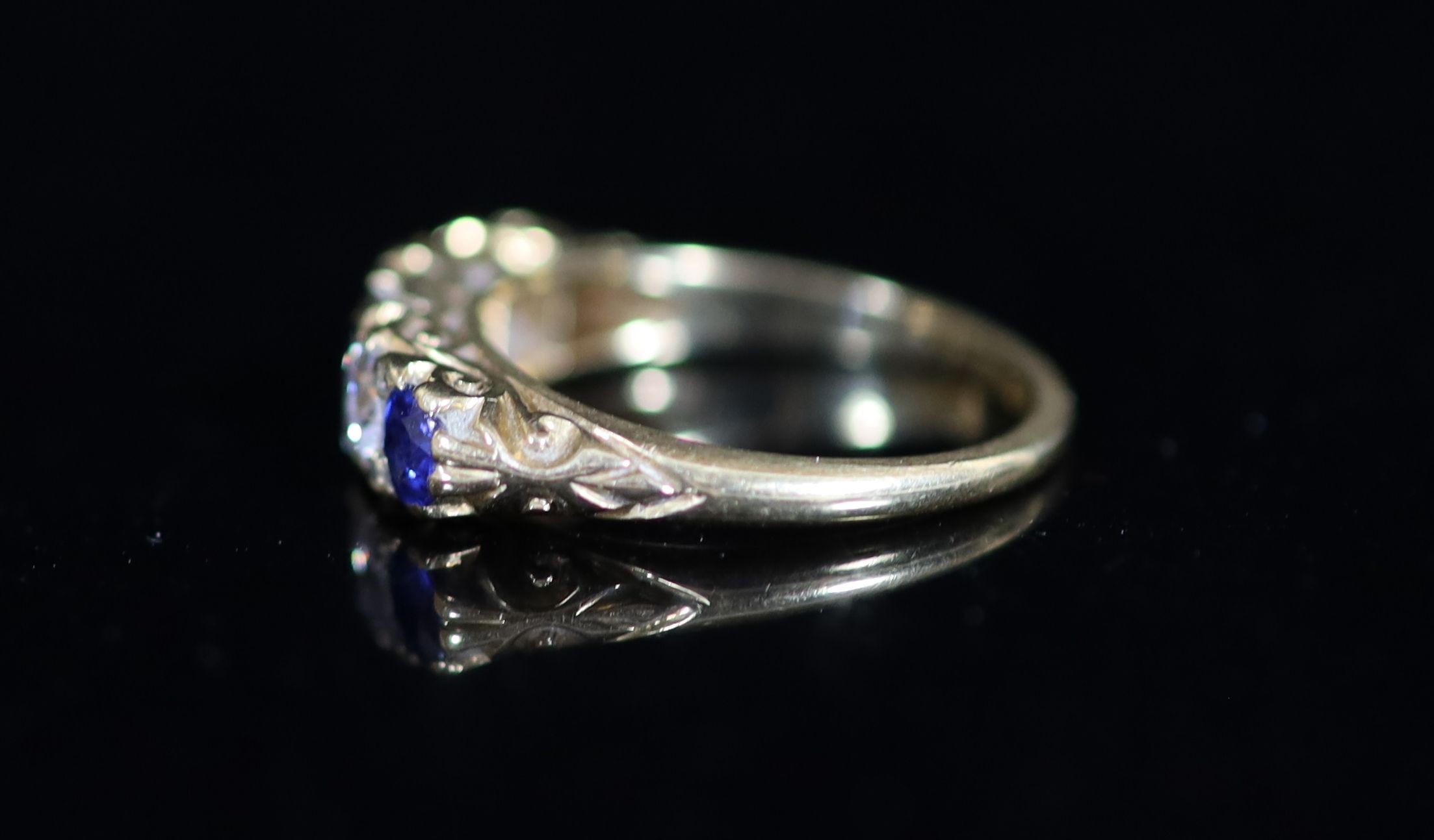 An early 20th century three stone sapphire and two stone diamond set half hoop ring